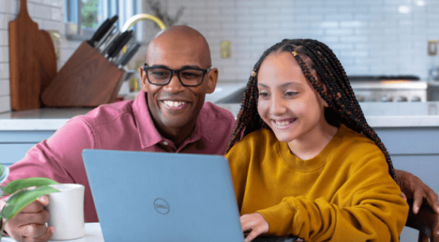 Photo of parent and child looking at laptop together