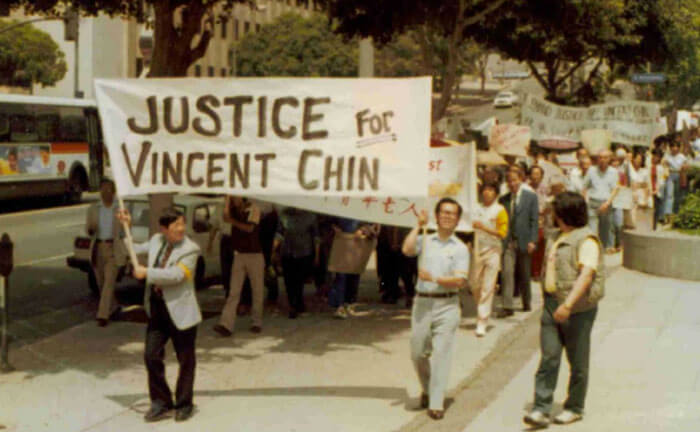 Photo de personnes défilant sous une bannière sur laquelle on peut lire Justice pour Vincent Chin
